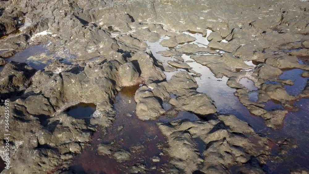 Flying over a reflection of the sky in puddles between rocks Flying over a reflection of the sky in puddles between rocks