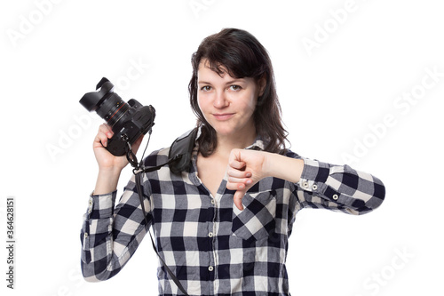 Young female freelance professional photographer or art student or photojournalist on a white background holding a camera with thumbs down photo