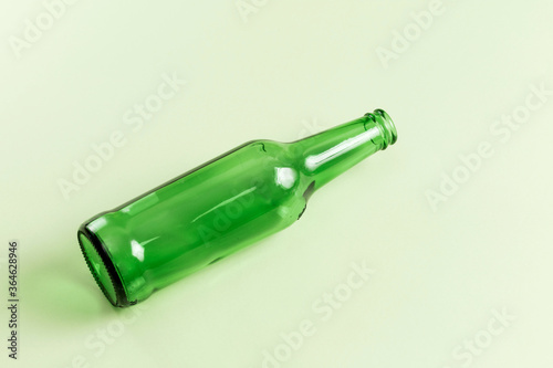 An empty wine bottle on a green background