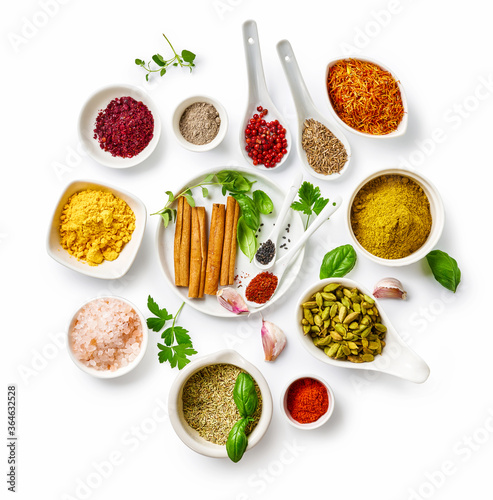 Different indian spices in a bowls and herbs on white background. Top view of indian spices with copy space.