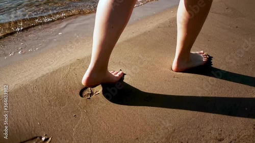 Woman walking on the beach, with waves in the background photo