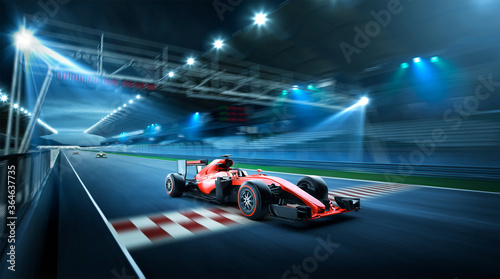 Fotografiet Race driver pass the finishing point and motion blur race track background