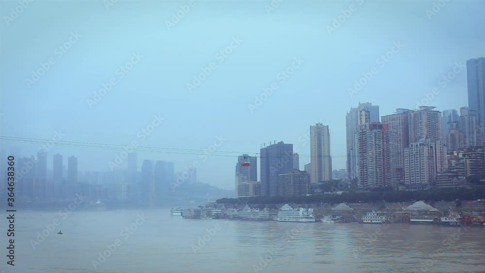 A ropeway cable car carries people across the river from the city above to the city below A ropeway cable car carries people across the river from the city above to the city below