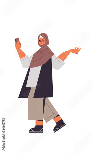 arabic woman in traditional clothes arab smiling girl using smartphone female cartoon character standing pose full length isolated vertical vector illustration