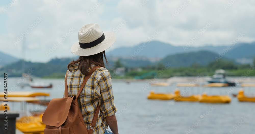 Travel woman sits on the pier