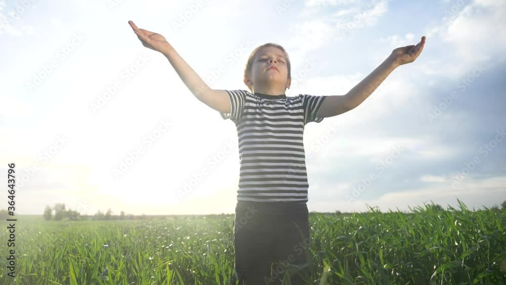 boy prays pulls hands to the sky against a blue sky. child concept faith religion and happy family. kid son hands to the side lifestyle against the blue sky jew praying to god. worship and gratitude boy prays pulls hands to the sky against a blue sky. child concept faith religion and happy family. kid son hands to the side lifestyle against the blue sky jew praying to god. worship and gratitude