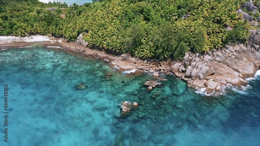 Birds eye view of beautiful white sand beach with rocks and turquoise ocean. Waves crushing on the beach and rocks. Mahe Island filmed in 4k Birds eye view of beautiful white sand beach with rocks and turquoise ocean. Waves crushing on the beach and rocks. Mahe Island filmed in 4k