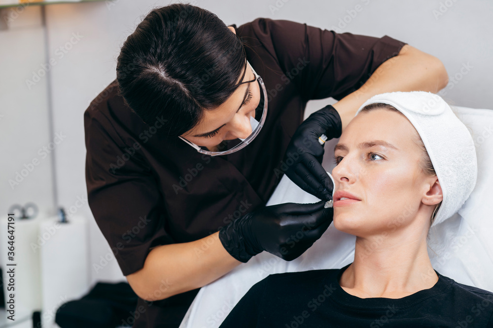 Doctor in gloves giving woman injections in lips Doctor in gloves giving woman injections in lips