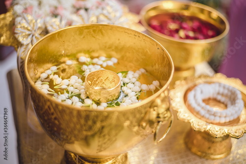 A set of the golden water bowl for holy water in the Thai wedding ceremony and the flower trays decoration.