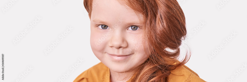 Red hair. Girl head portrait. Attractive little woman. Horizontal banner with copyspace. Sweet smile. Female child model. Funny young person. Positive expression. Looking at camera. Studio shot Red hair. Girl head portrait. Attractive little woman. Horizontal banner with copyspace. Sweet smile. Female child model. Funny young person. Positive expression. Looking at camera. Studio shot