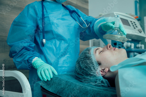 Medical worker giving general anesthesia to the patient photo