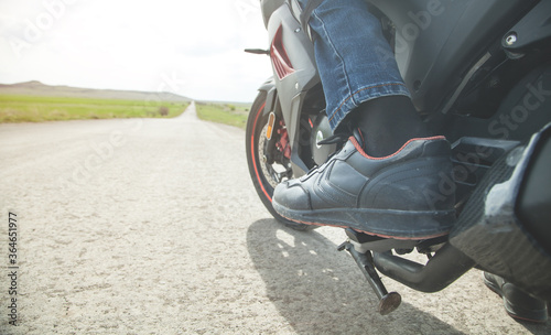 Motorcycle driver riding alone on asphalt motorway.