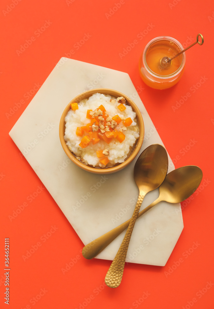 Bowl with boiled rice and pumpkin on color background Bowl with boiled rice and pumpkin on color background