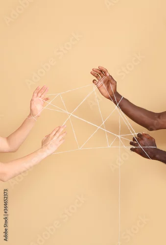 Obraz Hands of Caucasian woman and African-American man with ropes on color background. Racism concept