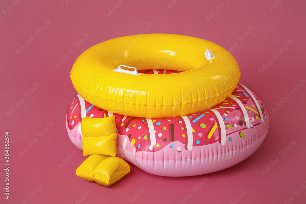 Inflatable rings and arm floats on color background Stock Photo | Adobe ...
