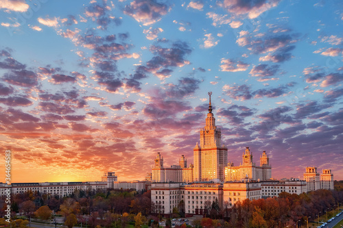 Panoramic aerial view of dramatic cloudy sky over old university in sunset