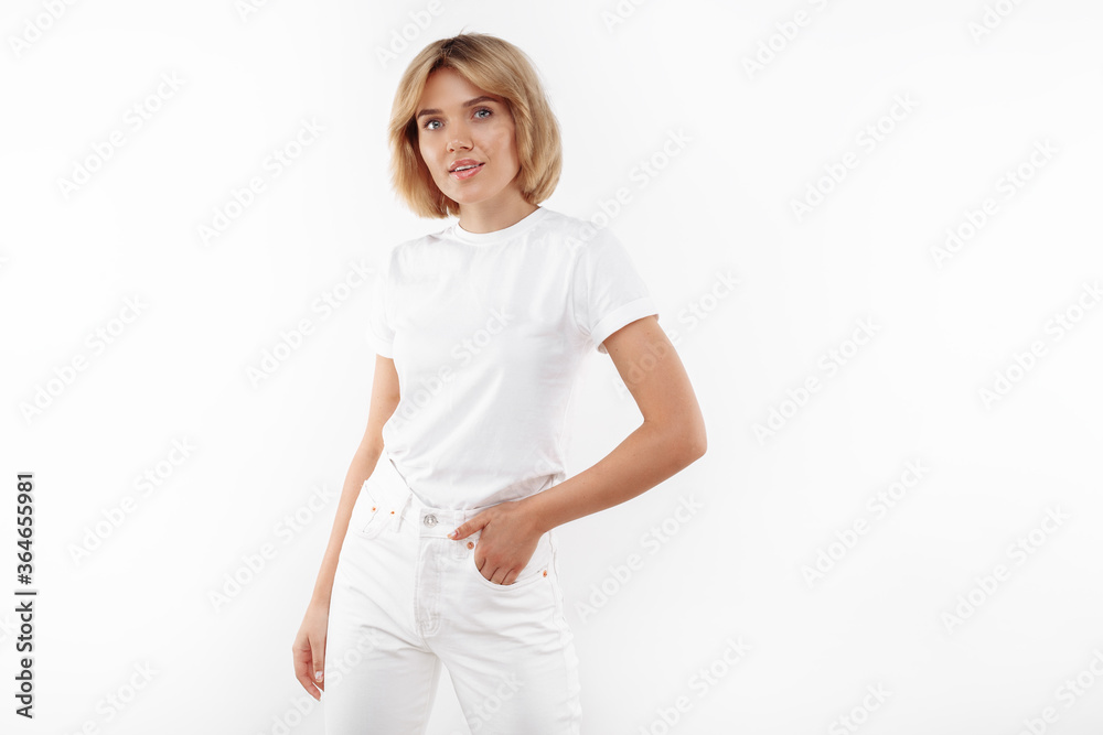 Pretty young blonde woman in casual white outfit posing over white background. Pretty young blonde woman in casual white outfit posing over white background.
