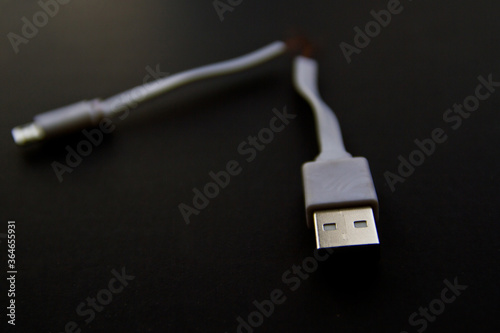 Broken smart phone charger cable isolated on black background with copy space