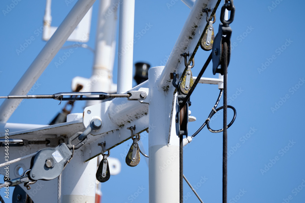 composition is navy consisting of a part of a fishingboat mast against a blue sky. Background consept composition is navy consisting of a part of a fishingboat mast against a blue sky. Background consept