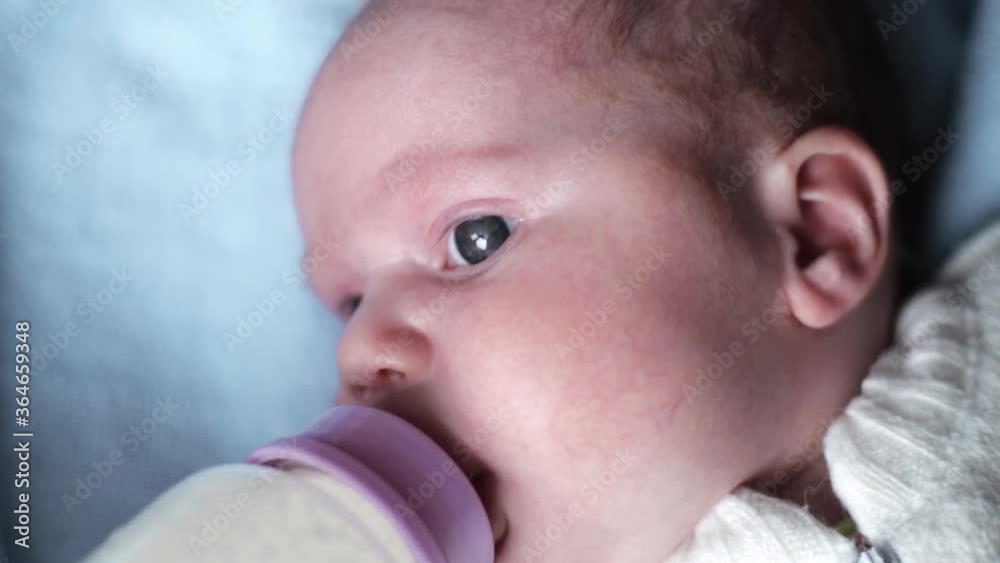 Closeup portrait of a cute little newborn baby being given milk through a feeding bottle. Closeup portrait of a cute little newborn baby being given milk through a feeding bottle.
