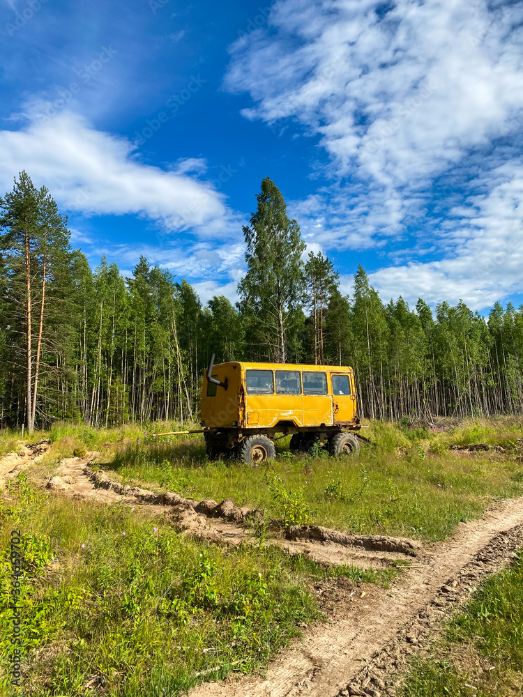 Yellow construction trailer, old bus in the wild in the forest Yellow construction trailer, old bus in the wild in the forest