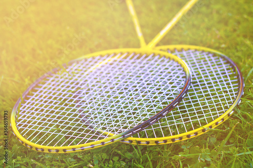 Badminton racket on the grass. Summer warm tone.