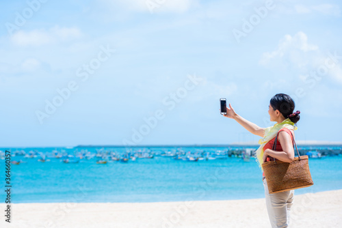 海の写真を撮る女性