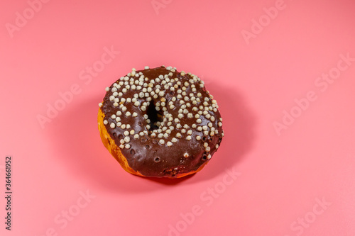 Tasty chocolate donut on a pink background