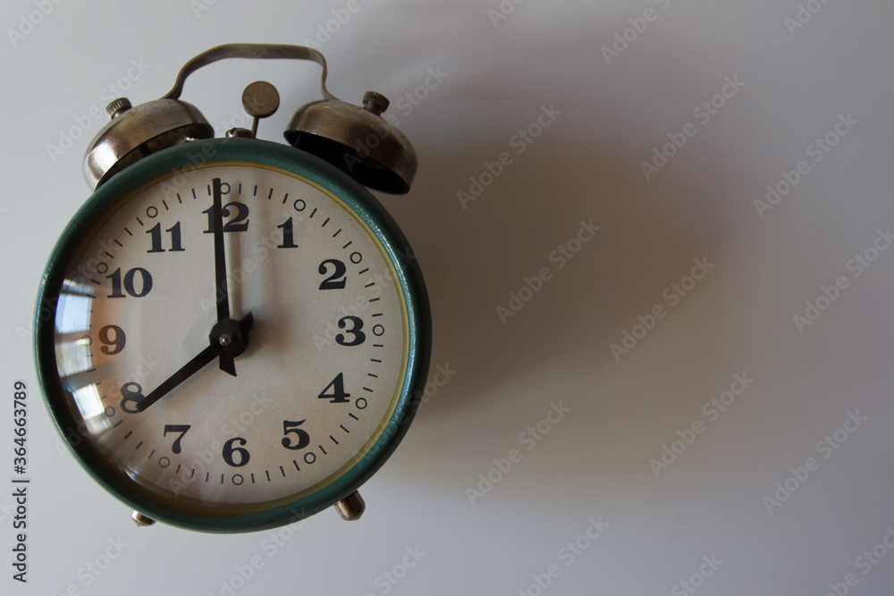 Green alarm clock on the light gray background Green alarm clock on the light gray background