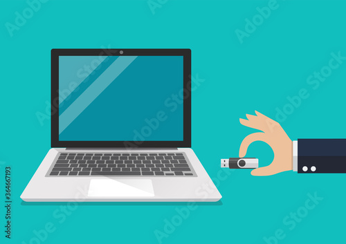 Businessman hand holding usb flash drive to connect a computer laptop photo
