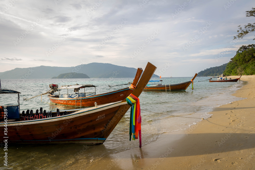 Koh Lipe / Thailand | August 03 2016: Long tail boats stopped in a paradise beach at Koh Lipe, Thailand Koh Lipe / Thailand | August 03 2016: Long tail boats stopped in a paradise beach at Koh Lipe, Thailand