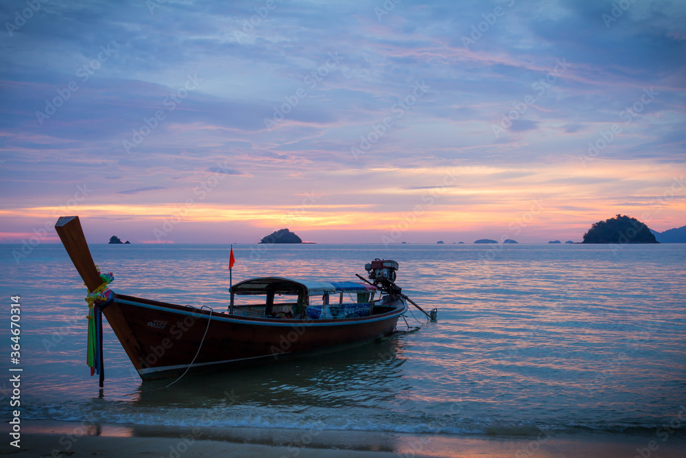 Koh Lipe / Thailand | August 03 2016: Longtail boat at beach on a purple sunset in Koh Lipe, Thailand
