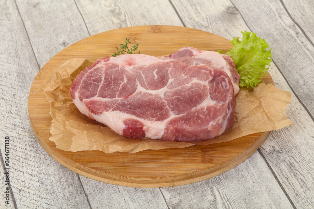 Raw pork steak over wooden board Raw pork steak over wooden board