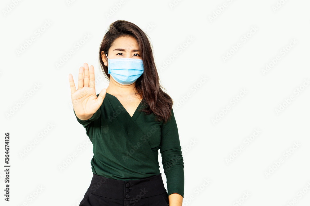 Asian woman wearing protective mask showing hand stop gesture ,social distancing,stop covid-19 concept Asian woman wearing protective mask showing hand stop gesture ,social distancing,stop covid-19 concept
