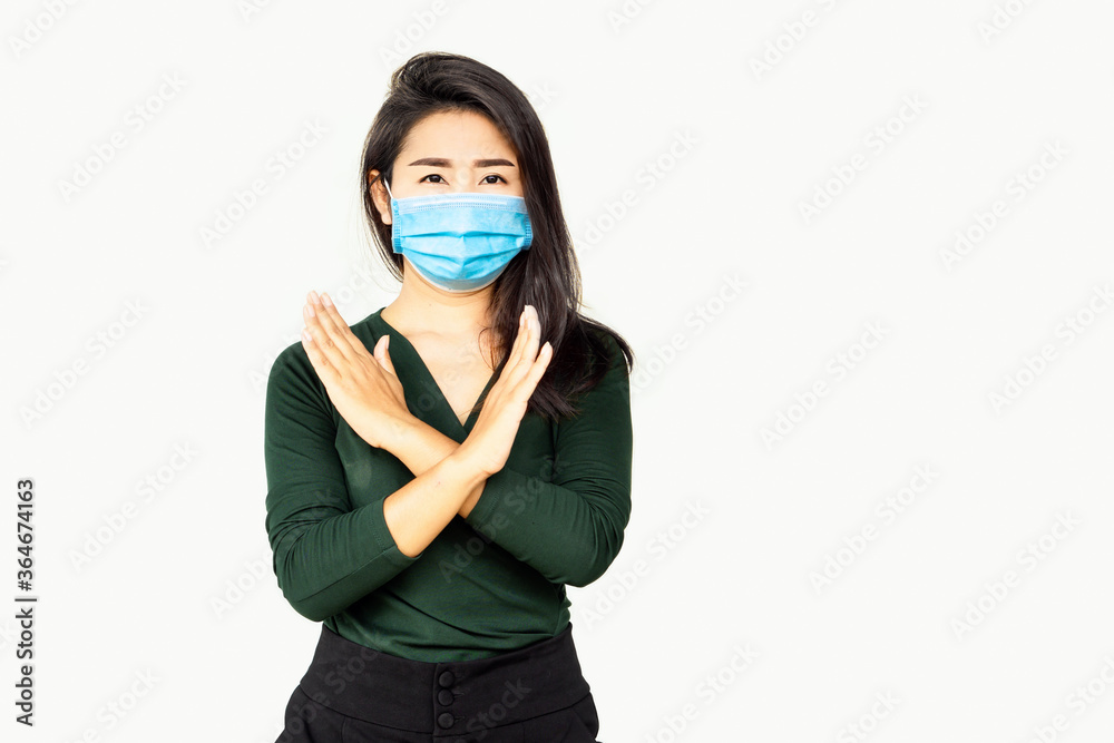 Asian woman wearing face mask making stop sign gesture, refusing coronavirus disease standing over grey background Asian woman wearing face mask making stop sign gesture, refusing coronavirus disease standing over grey background