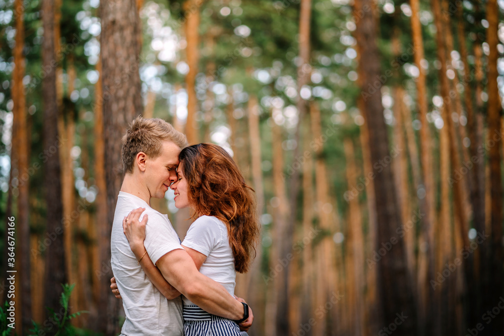 A couple in love has wonderful moments of happiness and joy in the pine forest. Love and tenderness.Lifestyle concept and place for text, copyspace A couple in love has wonderful moments of happiness and joy in the pine forest. Love and tenderness.Lifestyle concept and place for text, copyspace