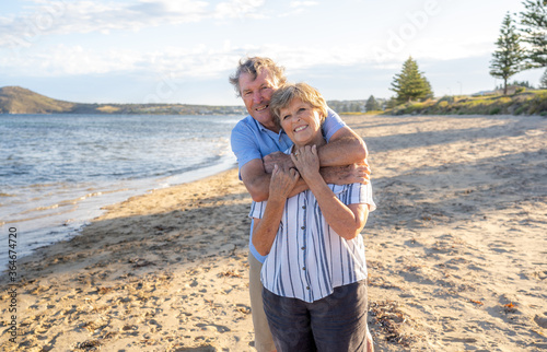 Portrait of happy senior couple at an empty remote beautiful beach on sunny day