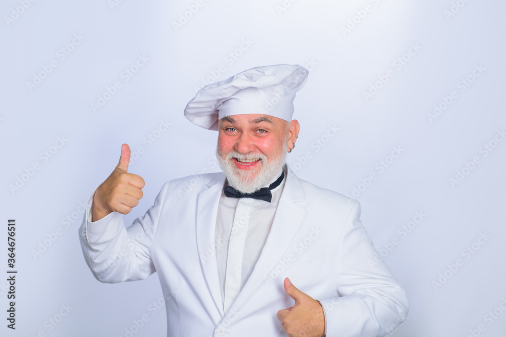 Male chef in white uniform shows thumb up. Cooking. Old bearded cook with perfect sign. Cooking concept. Professional chef man. Happy bearded chef, cook or baker. Smiling chef in uniform. Male chef in white uniform shows thumb up. Cooking. Old bearded cook with perfect sign. Cooking concept. Professional chef man. Happy bearded chef, cook or baker. Smiling chef in uniform.
