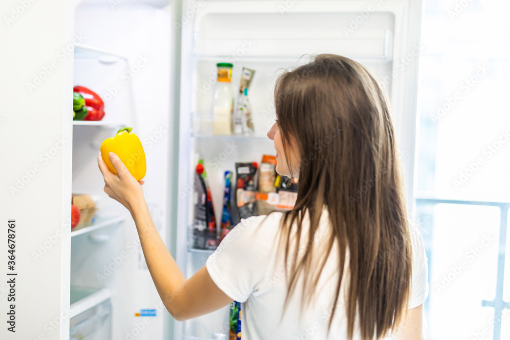 Healthy eating concept. Diet. Beautiful young woman near the refrigerator with healthy food. Fruits and vegetables in a Fridge Healthy eating concept. Diet. Beautiful young woman near the refrigerator with healthy food. Fruits and vegetables in a Fridge
