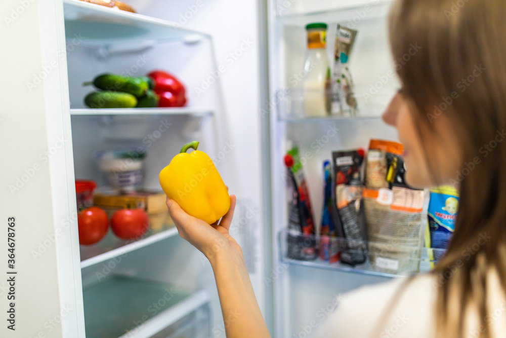 Healthy eating concept. Diet. Beautiful young woman near the refrigerator with healthy food. Fruits and vegetables in a Fridge