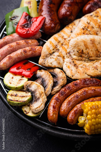 Grilled sausages, meat, and vegetables.