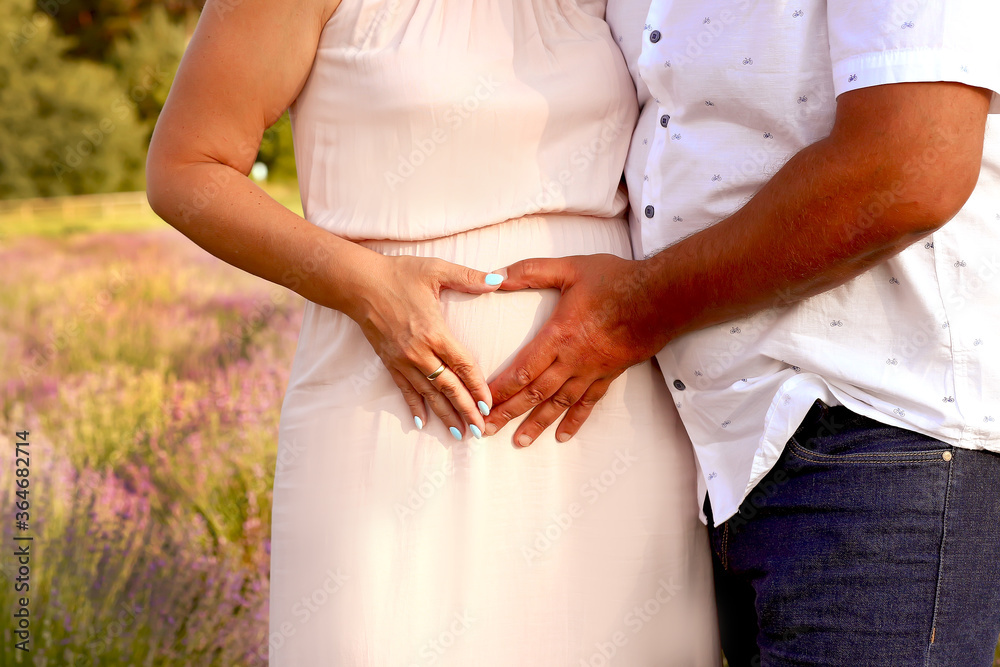 Married couple in anticipation of the baby. Close-up of parents hands on pregnant woman's belly. Love. A family. Pregnancy and parenthood concept