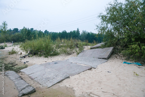 Metal rods and concrete parts of slabs. Damage to the planet's ecology caused by industrial, construction debris