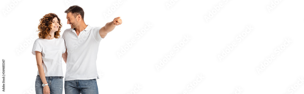 horizontal concept of happy man pointing with finger while looking at cheerful wife isolated on white horizontal concept of happy man pointing with finger while looking at cheerful wife isolated on white
