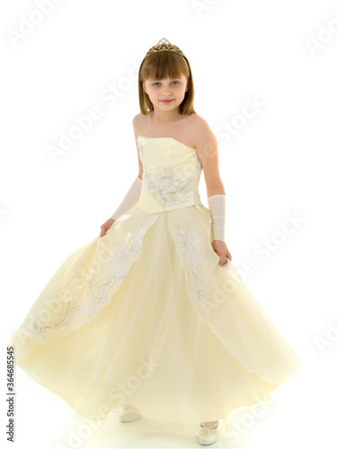 A little girl in a long  elegant dress of a princess.