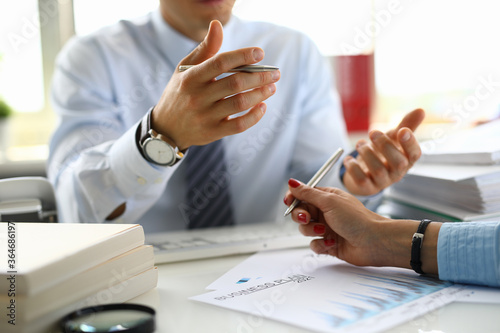 Φωτογραφία Businessman in an office holds pen in his hand and discusses abusiness plan for 2021 with colleague
