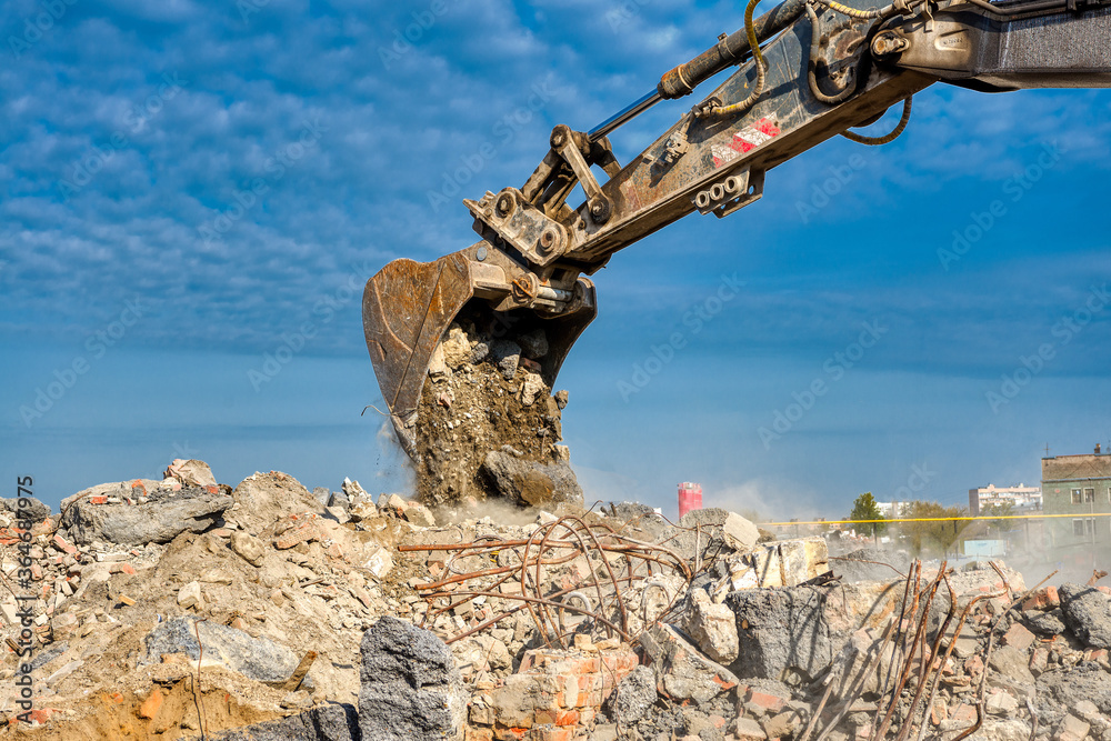 Fototapeta premium An excavator spills soil out of a bucket.