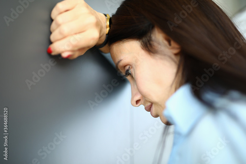 Cuadro en lienzo Sad woman is standing against wall with her elbow on her arm