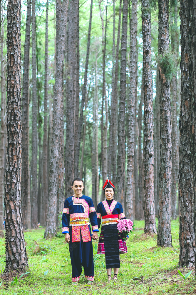 Couple hmongs holding hands and walking in the pine wood, Man and woman in Hmong clothes Couple hmongs holding hands and walking in the pine wood, Man and woman in Hmong clothes