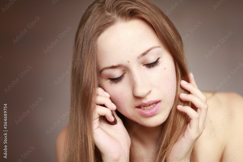 The beautiful girl is talking on the mobile phone. Girl portrait. Woman portrait. The beautiful girl is talking on the mobile phone. Girl portrait. Woman portrait.